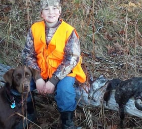 A young boy and his hunting dog