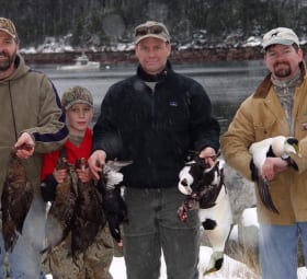 Four eager hunters holding up their ducks