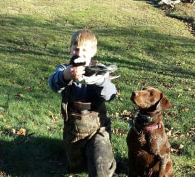 A young hunter and his chocolate lab